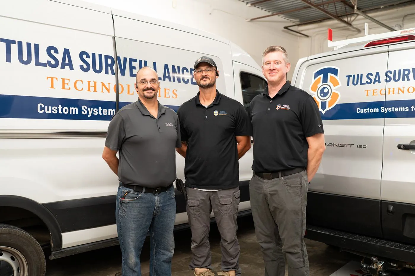 The Tulsa Surveillance Technologies crew standing in front of the company service vans