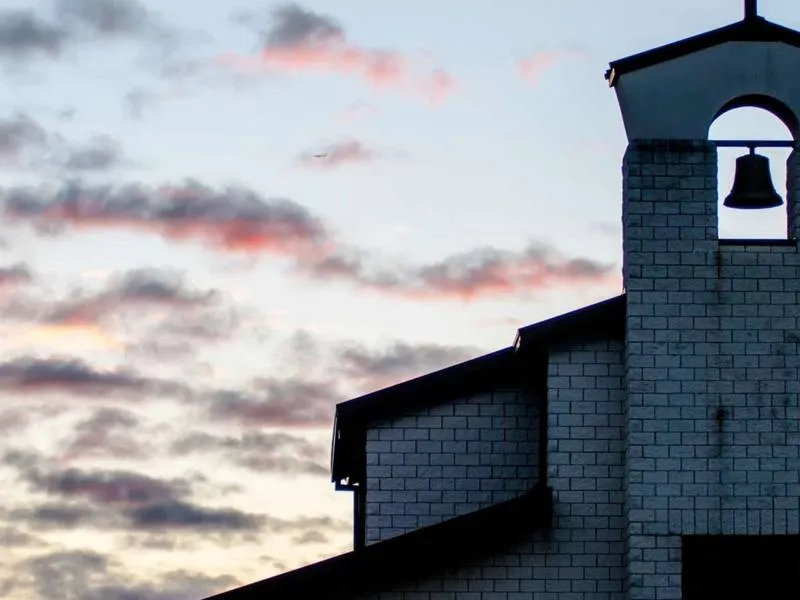 A church bell tower against a dusk sky