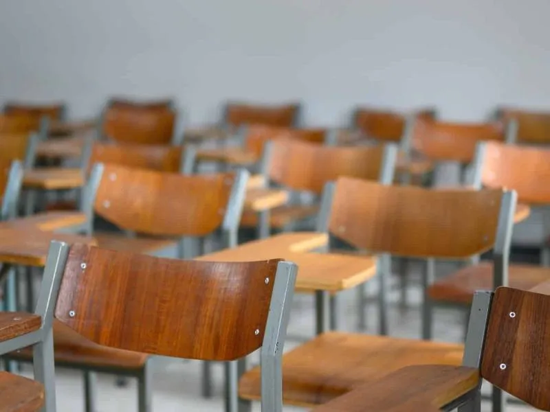 An empty classroom with rows of desks