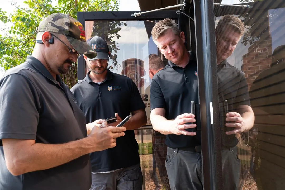 Tulsa Surveillance Technologies technicians testing mobile credentials at a commercial entry door